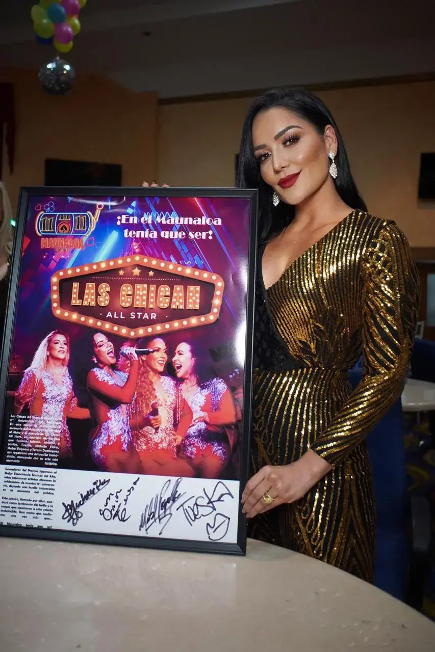 Artista posando con afiche de evento realizado en Maunaloa